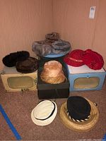 All vintage women's hats arranged with their boxes, showing colors and styles