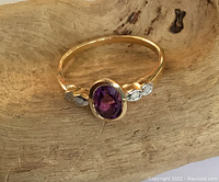 Front view of ring showing oval amethyst and two side diamonds