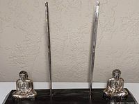 Front view of the set showing the two seated Sterling Silver Buddha figures flanking chopsticks held upright in holders on the onyx base.