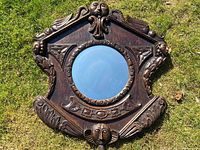 Overall front view of the carved oak mirror on grass background