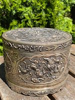 Front angle view showing embossed dragon and floral relief on body