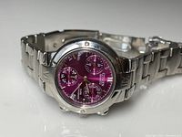 Full view of the Citizen watch lying on a flat surface showing the large round stainless steel case and purple dial with subdials