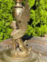 Close-up of winged sphinx support on brass column