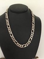 Necklace displayed on black bust showing full chain length and link style.