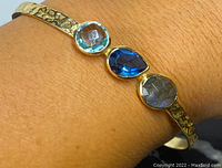 Bracelet on wrist showing three bezel-set gemstones