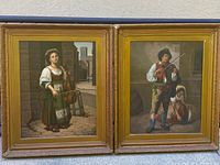 Both paintings side by side in their gilt frames, one female cellist scene on left and one male violinist scene on right