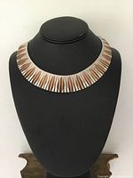 Front view of geometric collar necklace on display bust, showing rose gold vermeil overlay over sterling silver base with tapered segment design.