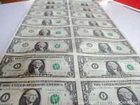 Front view of uncut sheet showing 16 one-dollar bills in a 4×4 arrangement
