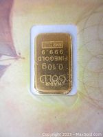 Close-up of gold bar in window, showing inscription and purity.