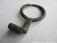 Close-up image of the ancient ring key showing patina and rectangular bit