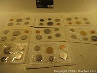 Full view of all eight sets sealed in plastic, showing multiple coins per set including pennies, nickels, dimes, quarters, half dollar and silver dollar coins.