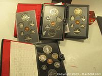 Four open presentation folders laid out showing each coin set