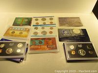 Overview of all nine coin sets arranged on a surface