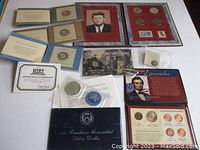 Full view of lot items including folders, certificates, coin holders, and portfolios.