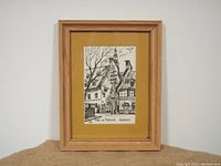 Framed art print in simple wooden frame with yellow matting shown fully.