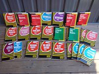 Top-down image showing a full set of vintage Coles Notes books on classic literature and science subjects arranged on a floor with visible titles like Macbeth, Julius Caesar, Hamlet, The Great Gatsby, physics and chemistry notes.