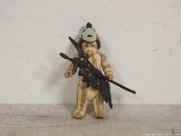 Logray Ewok Medicine Man action figure holding staff in one photo, standing against a plain white background on a wooden surface.