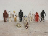 Overview of eight complete figures and two partial bodies on flat surface