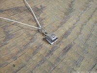 Photo of closed vintage sterling silver 925 engagement ring box pendant on chain, showing the intricate hinged box top.