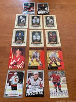 Full view of 14 NHL rookie cards arranged on a wooden surface