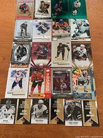 Top-down view of 17 NHL hockey insert cards laid out on a wooden surface, showing various players including Gretzky and Crosby.