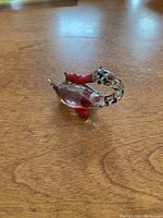 Top view of a red glass bird figurine showing multicolored speckled tail and red neck and feet