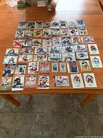 53 hockey goalie cards arranged in a grid on a table showing a variety of players and teams in goalie gear.