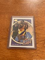 Front of Kobe Bryant Basketball Heroes trading card with image of Kobe in Lakers yellow jersey with basketball.