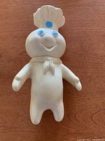 Front view of vintage Pillsbury Dough Boy figurine, showing white body, chef's hat, blue eyes and smiling face.
