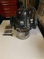 Black & Decker plunge router close-up with power cord wrapped around and ergonomic handle visible.