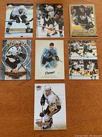 Full view of all 7 Sidney Crosby hockey cards laid flat on wood surface showing front image and condition.