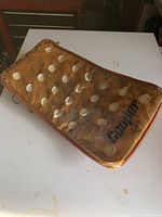 Top view of vintage Cooper goalie blocker showing tan leather surface with riveted padding and visible signs of wear, dirt, and discoloration