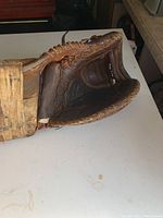 Vintage leather hockey goalie catcher glove showing inside padded catching area with worn leather and visible rips.