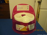 Front angle of pink and white child training potty, showing label and overall condition.
