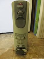 Front view of the DeLonghi Magnum oil filled radiator heater showing brand label, heat level dial and thermostat knob