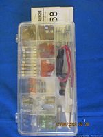 Closed plastic case showing fuses and accessories inside.