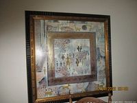 Large framed picture with abstract stylized human and animal figures and alphabetic symbols, framed in dark wood with a gold beaded edge.