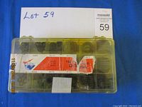 Top view of the closed transparent plastic compartment box containing multiple O-rings of various sizes with a seller note and lot number visible.