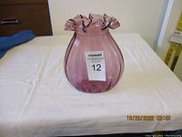 Front view of the purple glass vase showing the ruffled top edge and bulbous shape.