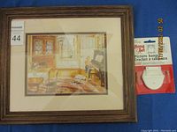 Framed print by Tricia Romance with a child playing piano in a warm interior, shown fully framed against a blue background with a picture hanger kit nearby.