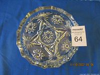 Top view of the circular clear glass ashtray highlighting the raised Star of David and starburst design.