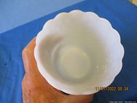Top view of the white milk glass vase showing smooth interior and scalloped opening.
