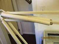 Close-up image showing the extendable arm of the vintage magnifier lamp, highlighting the hinge points and spring-loaded cylinders that help with arm adjustment and flexibility.