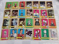 A spread of 28 hockey cards from the 1971-72 O-Pee-Chee set laid out showing player, action and trophy cards with colored borders.