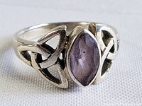 Close-up front angle showing marquise-faceted amethyst in sterling silver setting with Celtic knot band design.