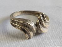 Close-up angled view of the sterling silver ring showing the classic flare design and surface texture.