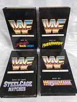 Four black WWF Collector's Edition VHS tapes with titles Best of Saturday Nights Main Event, Best of Hulkamania, Best of Steelcage Matches, Best of Wrestlemania.