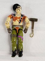 Full body view of GI Joe figure next to hammer accessory on white background