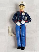 Full view of G.I. Joe figure lying down with gun accessory beside it.