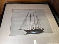 Framed black and white photograph of the USCG Trawler Atlantic, showing the full ship with its tall sails and masts visible